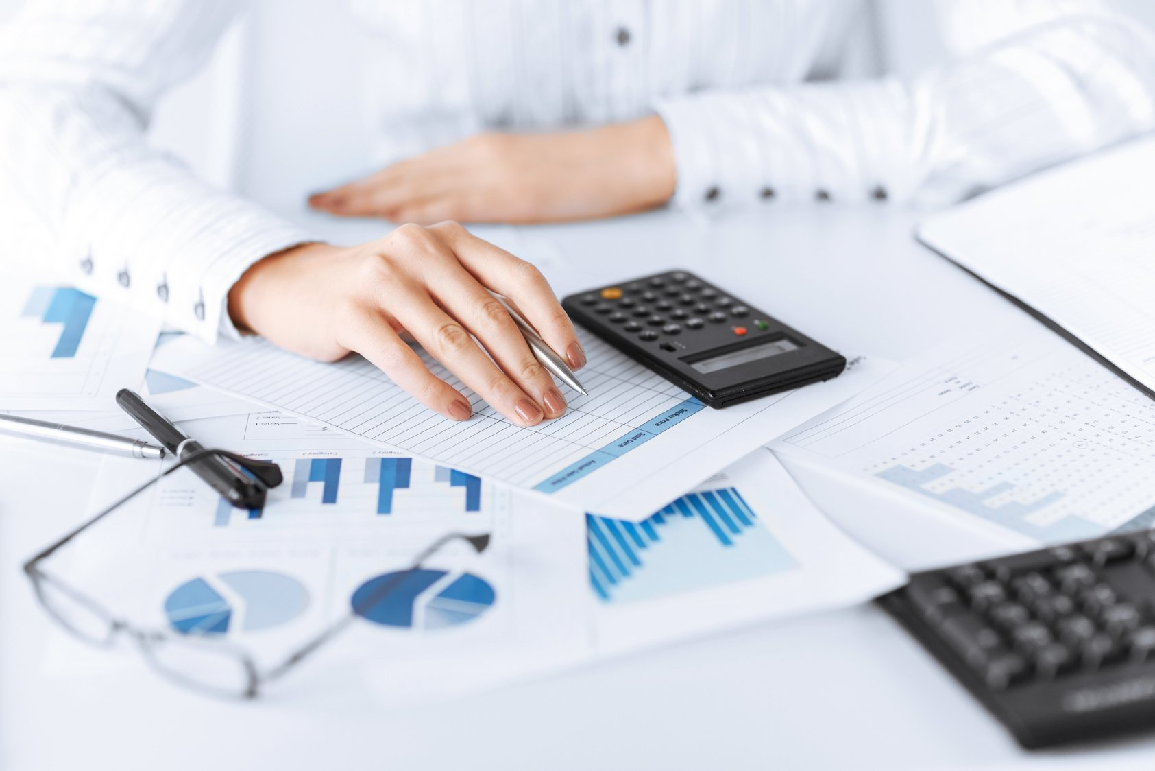 Woman Hand with Calculator and Papers